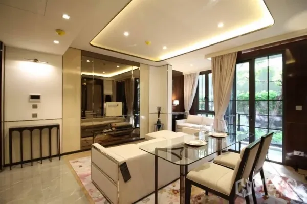 Condominium for rent in Watthana, Bangkok - Bright living and dining area with glass table beside floor-to-ceiling windows opening to garden views.