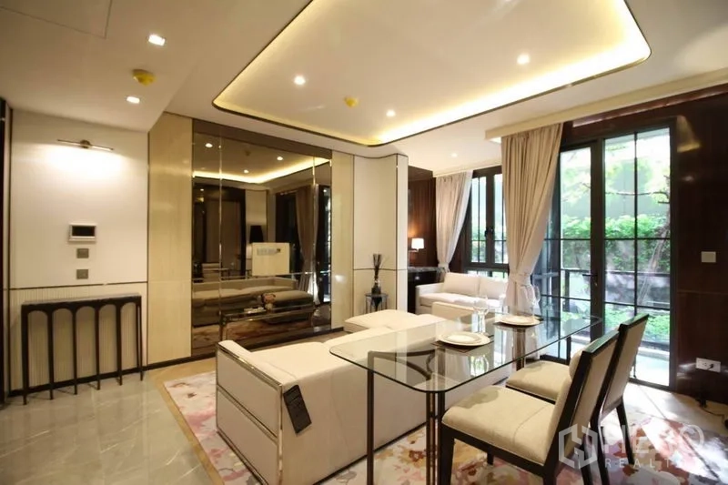 Condominium for rent in Watthana, Bangkok - Bright living and dining area with glass table beside floor-to-ceiling windows opening to garden views.