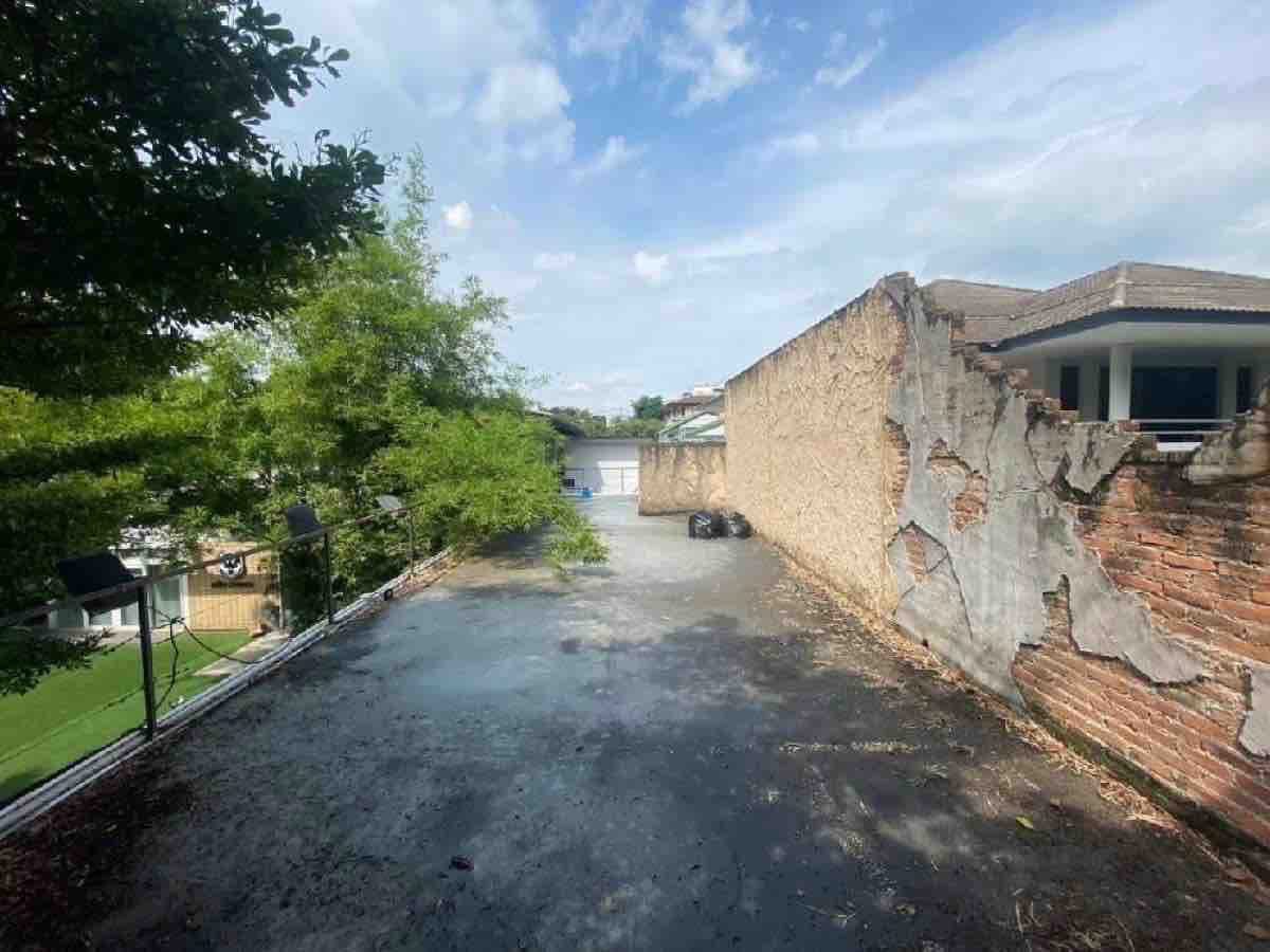 零售空间 出租在Watthana, Bangkok - 屋顶露台，沿老砖墙与绿植而设，适合户外座位或招牌。