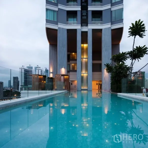 Condominium for rent in Watthana, Bangkok - Condominium infinity-edge swimming pool with glass balustrade and city skyline views.