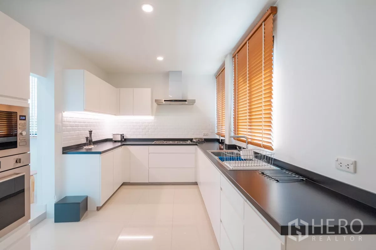 บ้าน ขายในSaphan Sung, Bangkok - ครัวสไตล์โมเดิร์นรูปตัว U ตู้สีขาว ท็อปสีดำ และหน้าต่างยาว