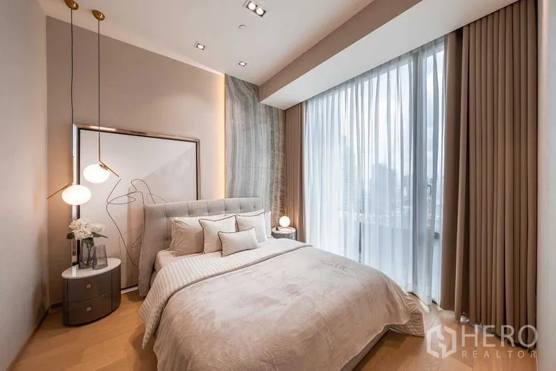 Condominium for rent or sale in Pathum Wan, Bangkok - Cozy bedroom with upholstered bed and panoramic window overlooking the city.