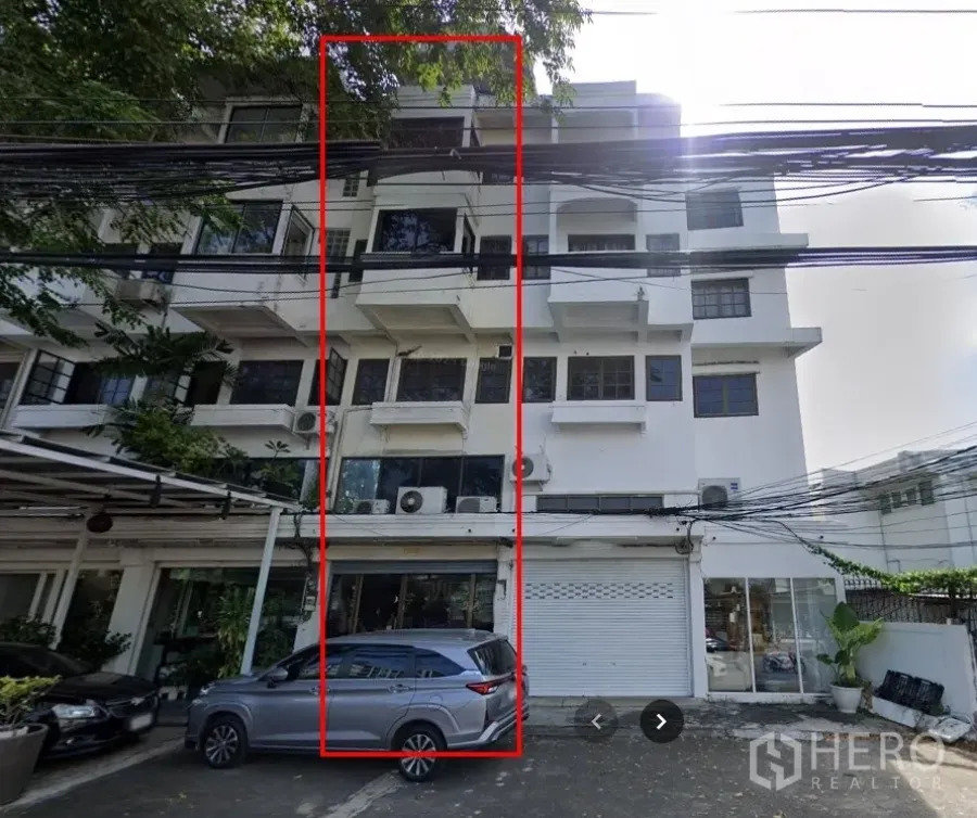 店屋 出租在Phra Khanong, Bangkok - 4.5层白色商铺楼外立面，底层店面与门前停车位。