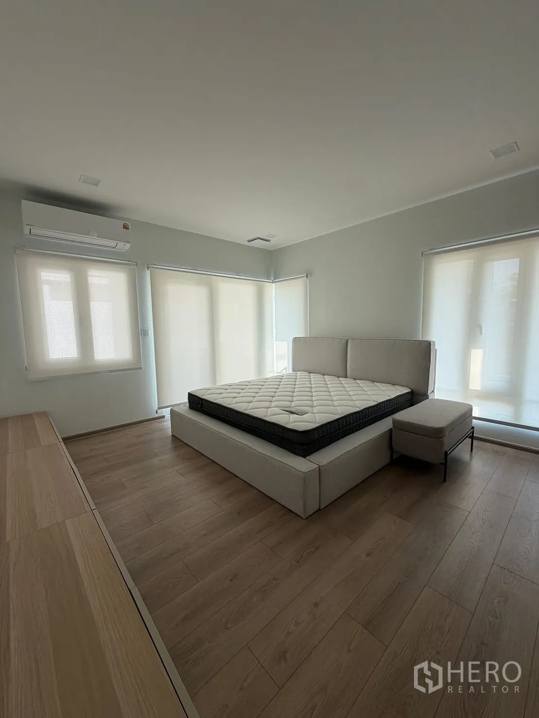 บ้าน ให้เช่าในBang Na, Bangkok - ห้องนอนหลัก หน้าต่างบานใหญ่ เตียงบุผ้าและสตูลปลายเตียง