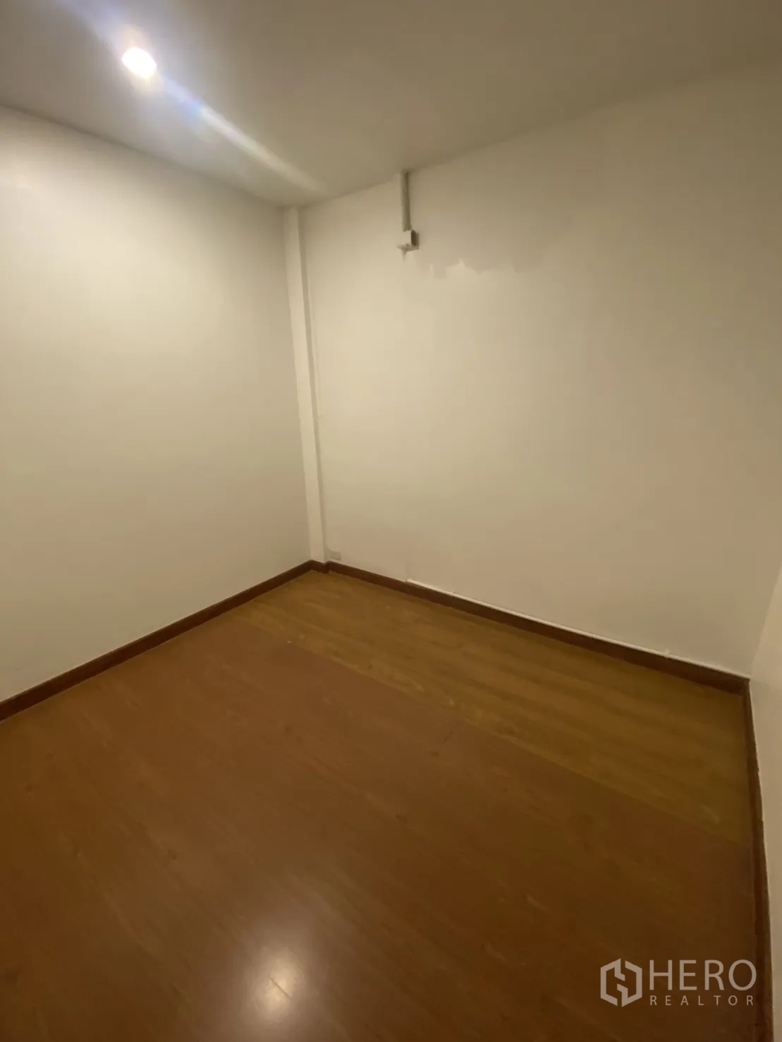 Shophouse for rent in Bang Rak, Bangkok - Compact room with wood-look flooring and recessed ceiling light.