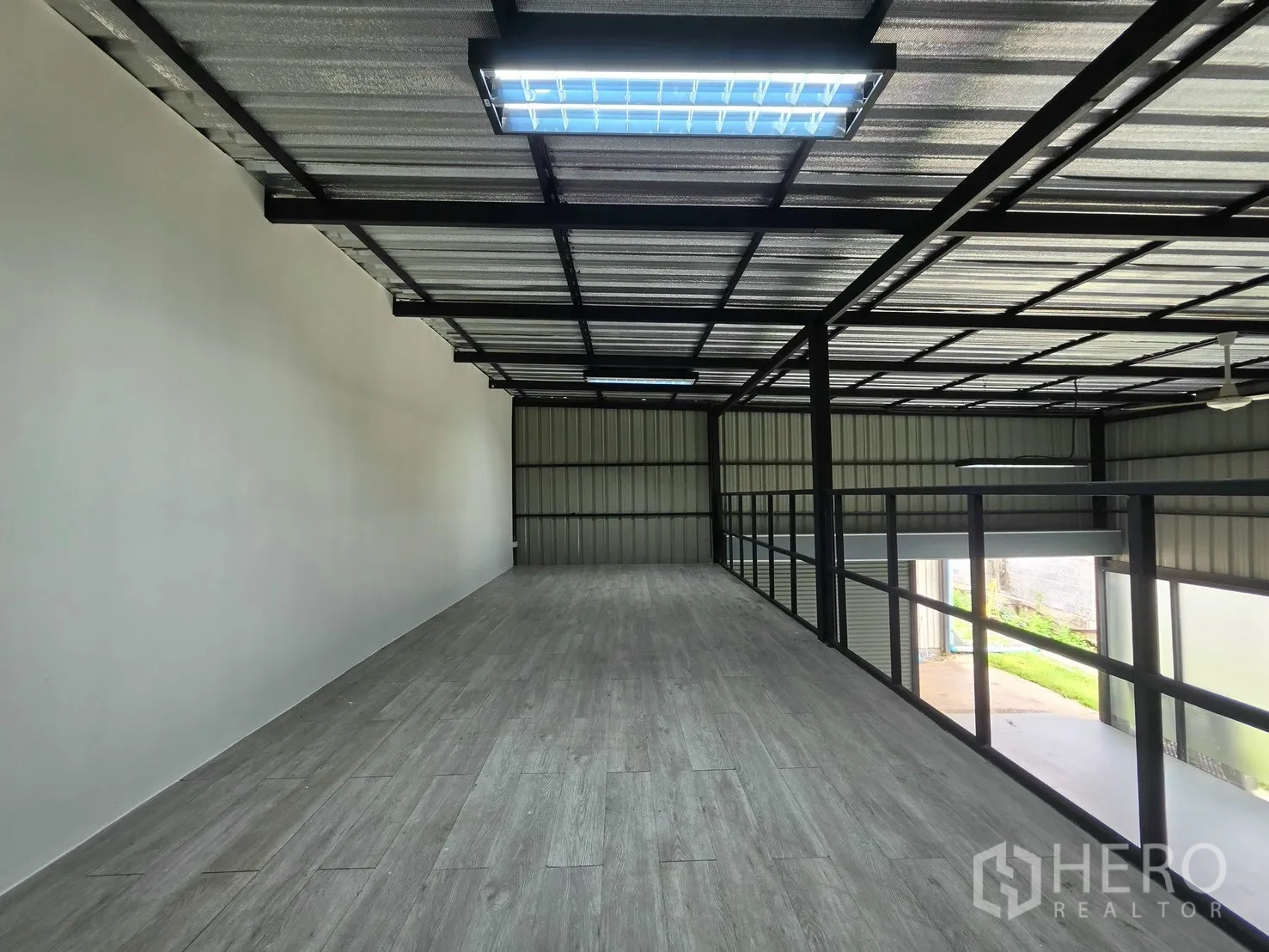 Warehouse for rent in Suan Luang, Bangkok - Long mezzanine walkway with railing and strip lights above.
