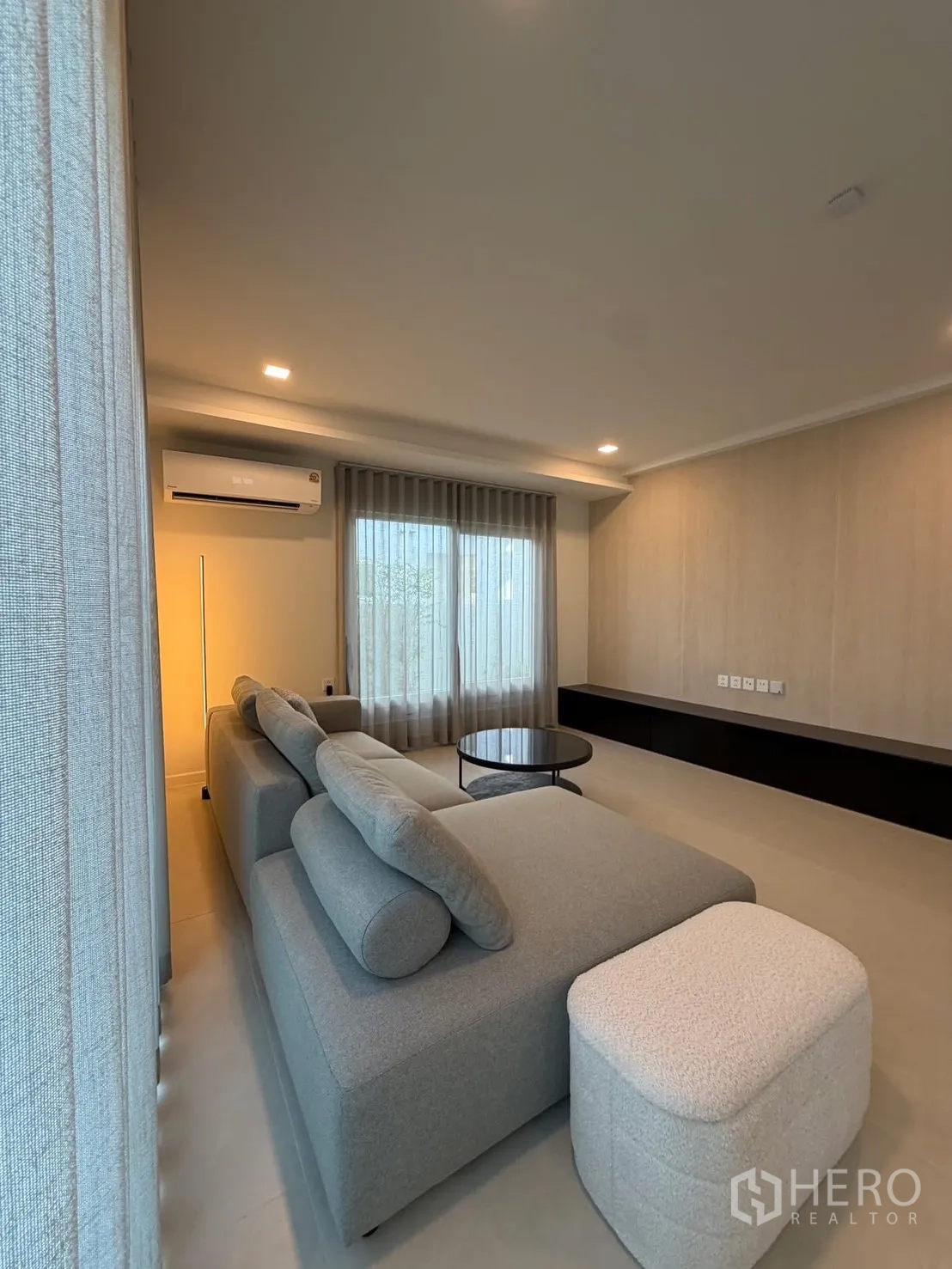 บ้าน ให้เช่าในBang Na, Bangkok - ห้องนั่งเล่นอบอุ่น โซฟาเข้ามุม โต๊ะกลางทรงกลม และไฟนุ่มนวล