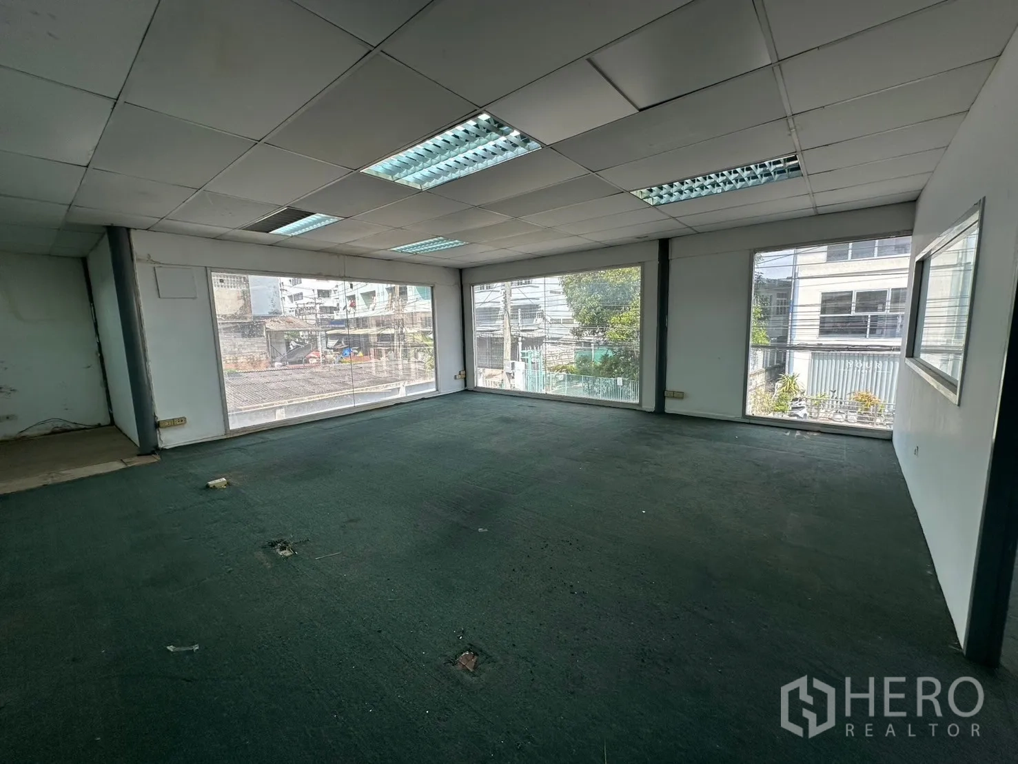 Warehouse for rent in Suan Luang, Bangkok - Open office space with multiple large windows and suspended ceiling lights.