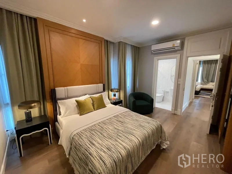 บ้าน ให้เช่าหรือขายในSaphan Sung, Bangkok - ห้องนอนพร้อมผนังไม้ตกแต่ง แสงไฟนุ่มนวล และห้องน้ำในตัว