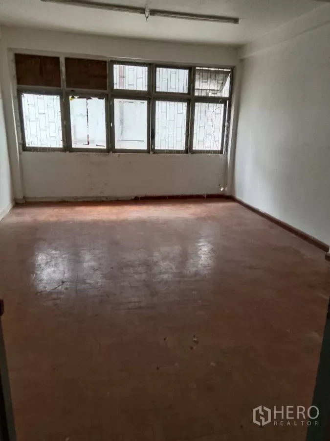 店屋 出租在Bang Rak, Bangkok - 楼上空房，金属框大窗与旧人字木地板。