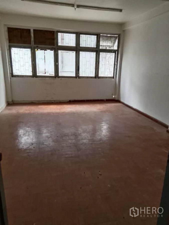 店屋 出租在Bang Rak, Bangkok - 楼上空房，金属框大窗与旧人字木地板。