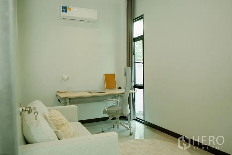 บ้าน ขายในPhra Pradaeng, Samut Prakan - ห้องทำงานมินิมอลพร้อมโต๊ะ เก้าอี้ทำงาน และโซฟาขนาดเล็ก ใต้เพดานสูง
