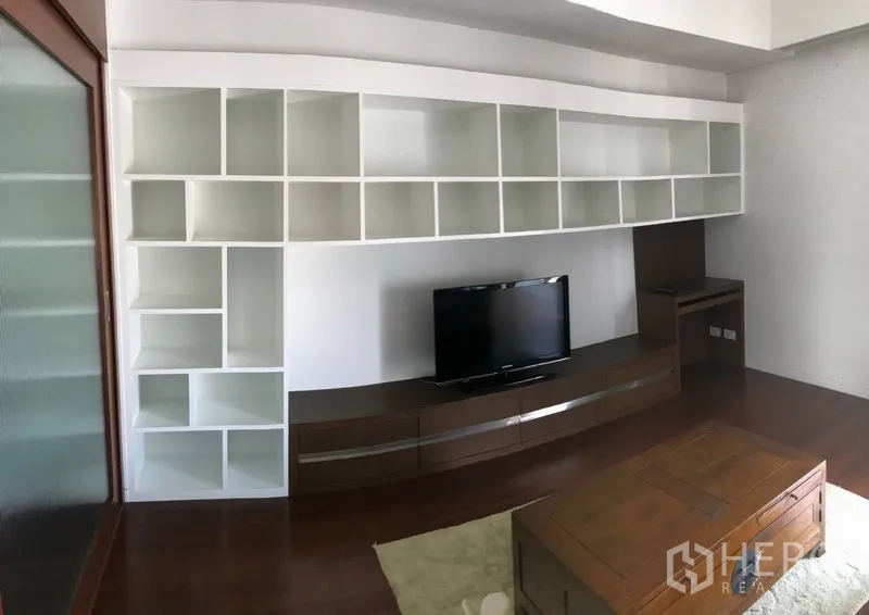 公寓 出租在Pathum Wan, Bangkok - 客厅内置白色置物架、电视柜与深色木地板