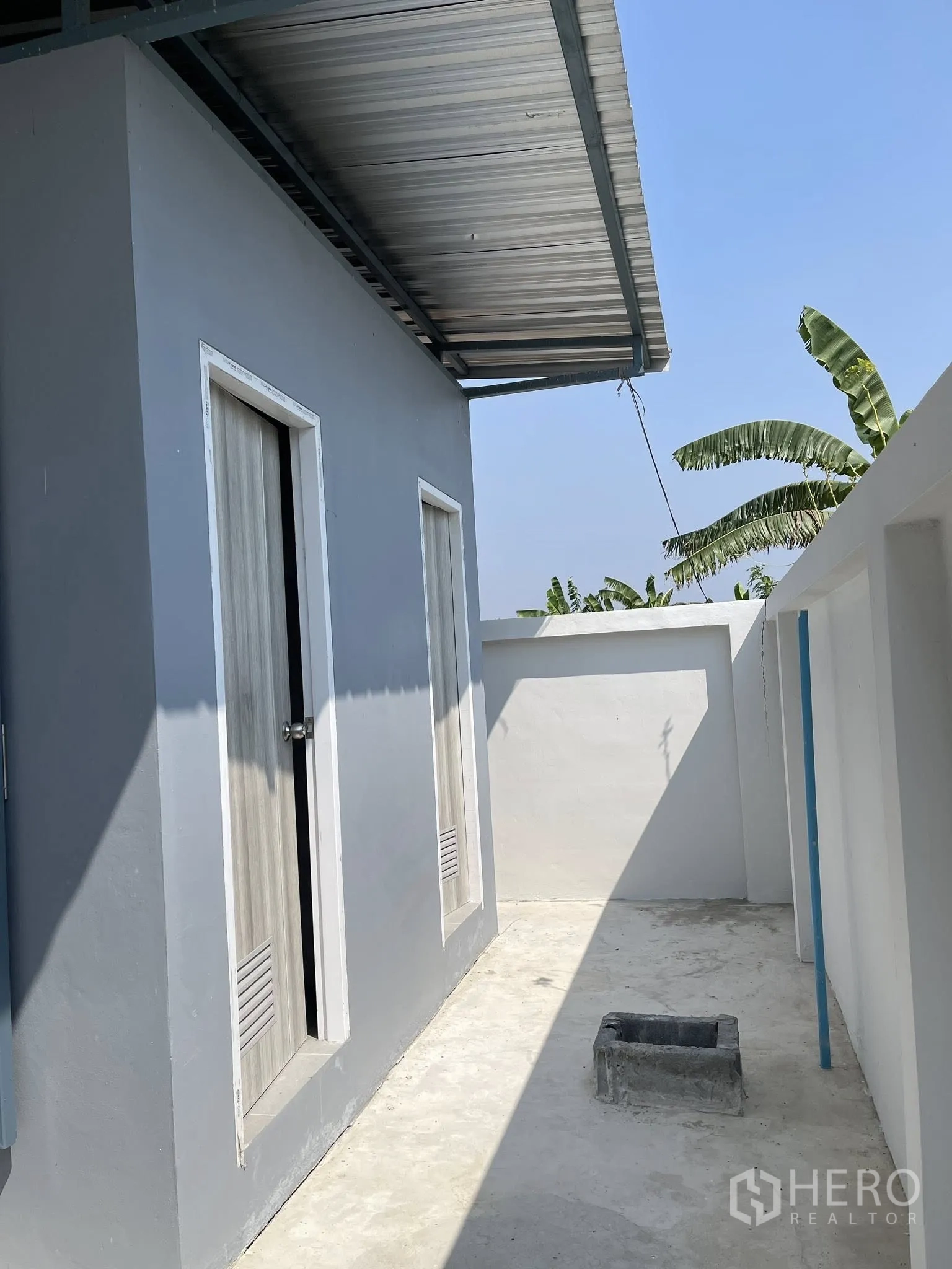 Factory for rent or sale in Bang Phli, Samut Prakan - Small external utility area with two doors under a metal roof.