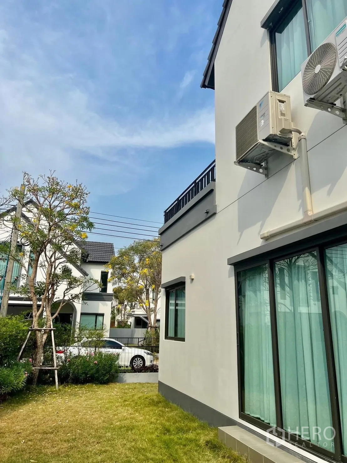 บ้าน ให้เช่าในBang Sao Thong, Samut Prakan - สนามหญ้าข้างบ้านกับต้นไม้ ภายนอกติดแอร์ และบ้านเพื่อนบ้านในโครงการ