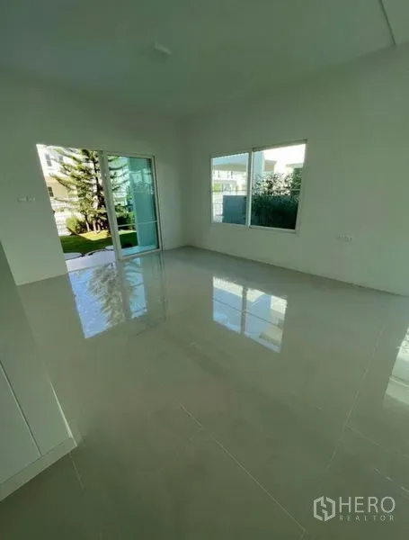 บ้าน ให้เช่าในMin Buri, Bangkok - ห้องนั่งเล่นสว่าง พื้นกระเบื้องเงา หน้าต่างบานใหญ่และประตูบานเลื่อนเปิดออกสู่สวน ในบ้านเดี่ยวมีนบุรี