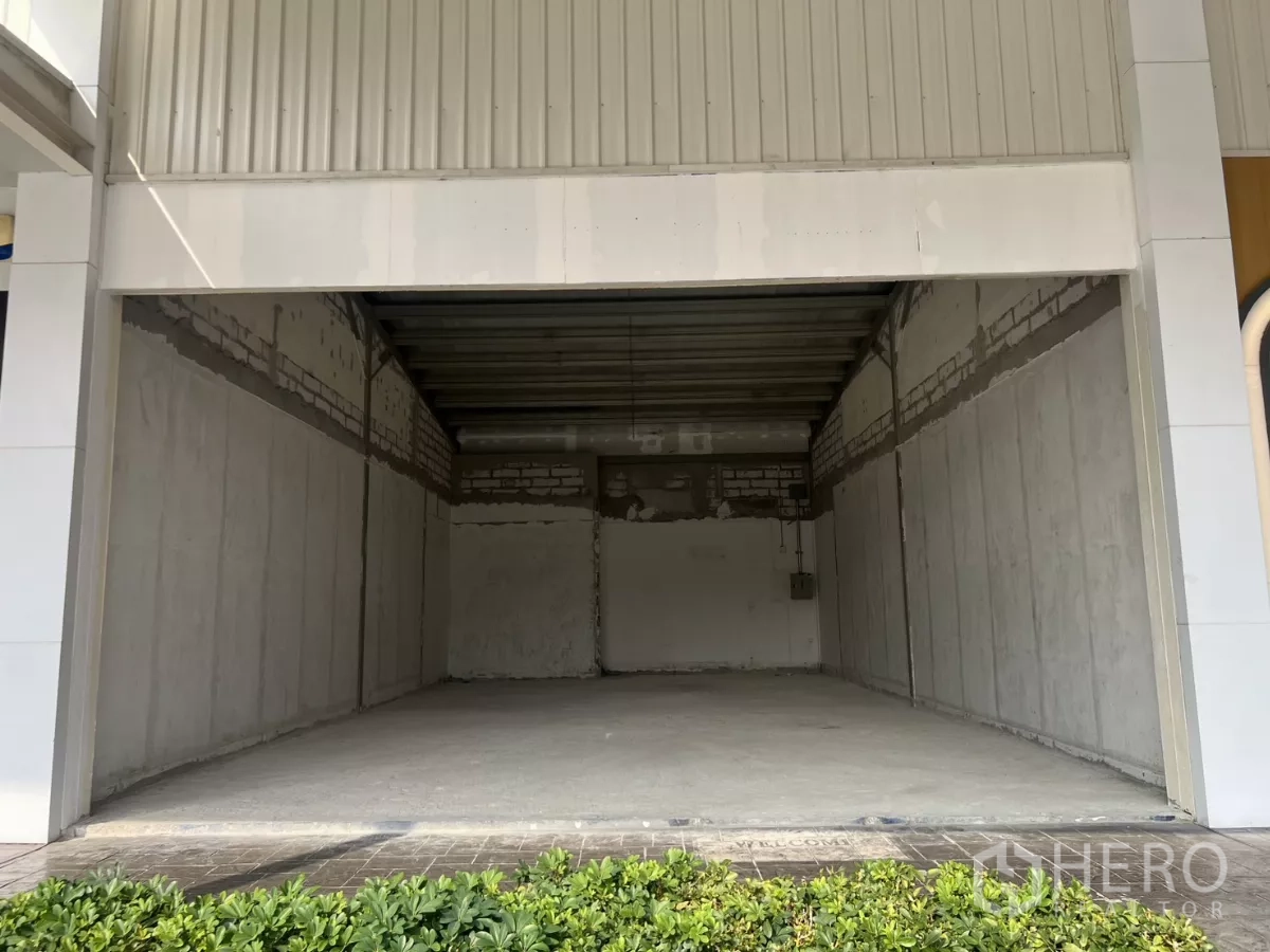 零售空间 出租在Watthana, Bangkok - 商铺外立面，带有遮雨门廊与前方绿化带。