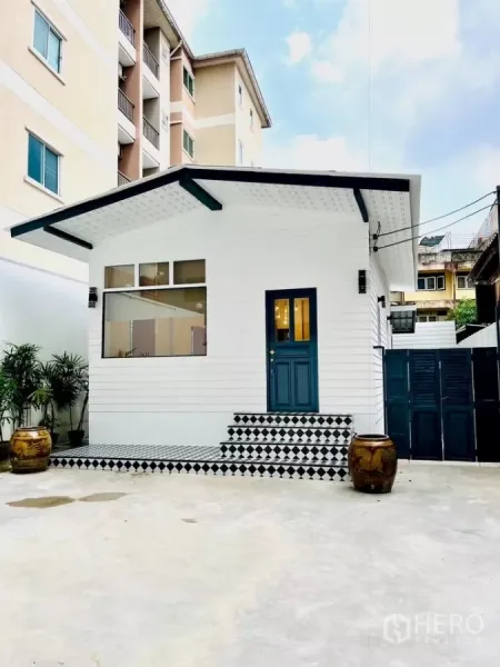 Detached House for rent - Front view of a newly refreshed white detached house with blue door and checkered steps in Sathorn, Bangkok.