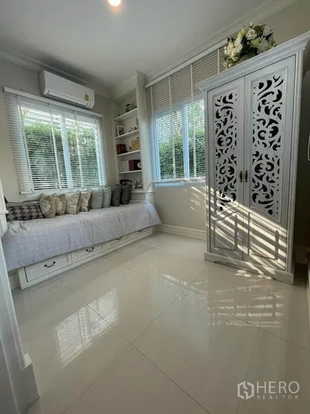Detached House for rent or sale in Pathum Thani - Bright multipurpose room with daybed, built-in shelves and large windows.