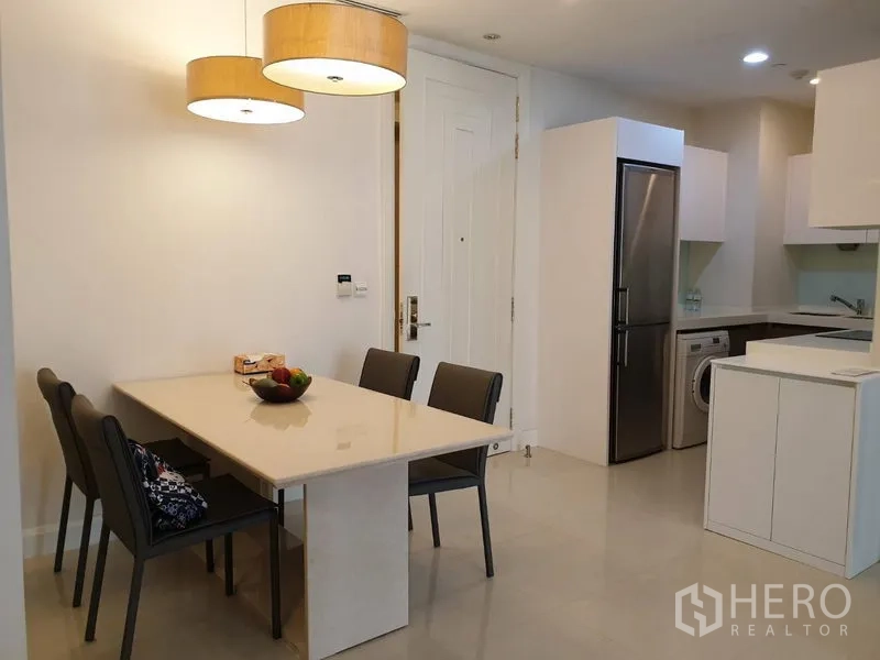 Condominium for rent in Pathum Wan, Bangkok - Dining area with four-seat table, pendant lights and access to the compact kitchen.