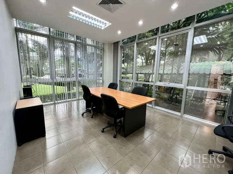 Office Space for rent in Bueng Kum, Bangkok - Corner meeting room with floor-to-ceiling windows, garden views, and a conference table with office chairs.