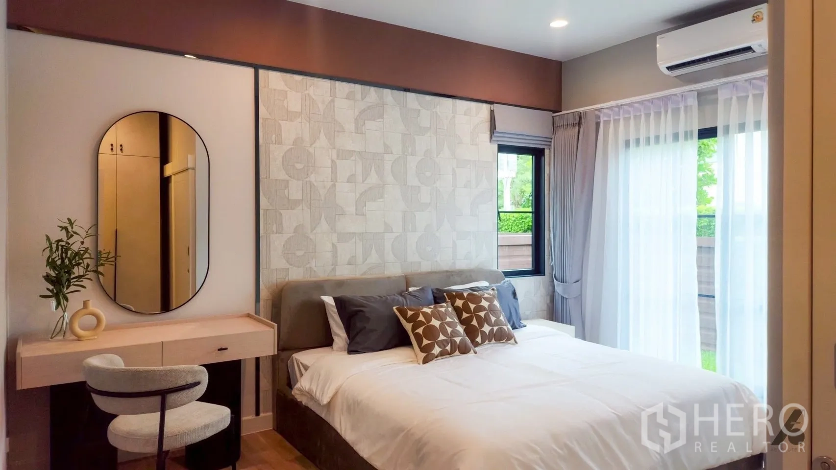 Detached House for rent in Bang Phli, Samut Prakan - Cozy ground-floor bedroom with patterned feature wall, vanity, and garden-view windows.