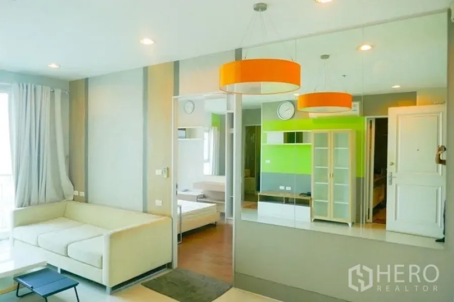 คอนโด ให้เช่าหรือขายในKhlong San, Bangkok - โถงพักผ่อนแบบโอเพ่นสเปซ โคมไฟแขวนสีส้ม ผนังกระจก และโซฟา มองเห็นห้องนอน