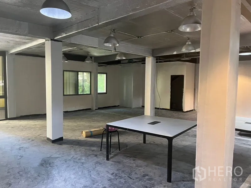 零售空间 出租在Pathum Wan, Bangkok - 工作区视角，吊灯、窗户与白色展示桌。