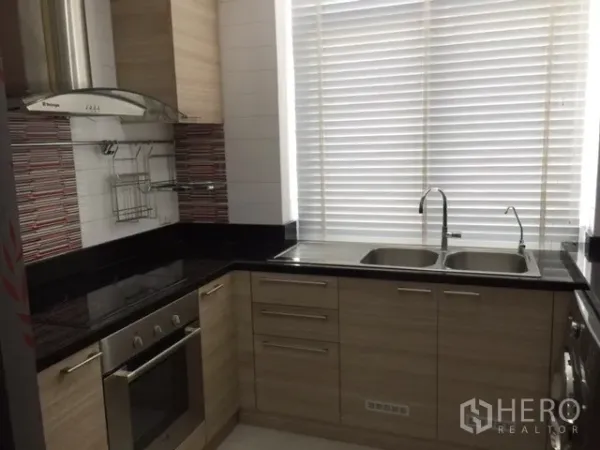 คอนโด ให้เช่าหรือขายในKhlong Toei, Bangkok - ครัวปิดทรงตัวแอล เคาน์เตอร์หินสีดำ เตาอบ เครื่องดูดควัน และอ่างล้างจานสองหลุม ใกล้หน้าต่างบานใหญ่