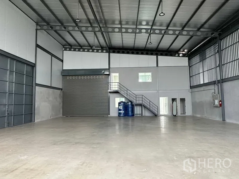 คลังสินค้า ให้เช่าในSamut Prakan - พื้นที่จัดเก็บกว้าง เพดานสูง ประตูม้วน หน้าต่างบานเล็ก และมุมสาธารณูปโภค