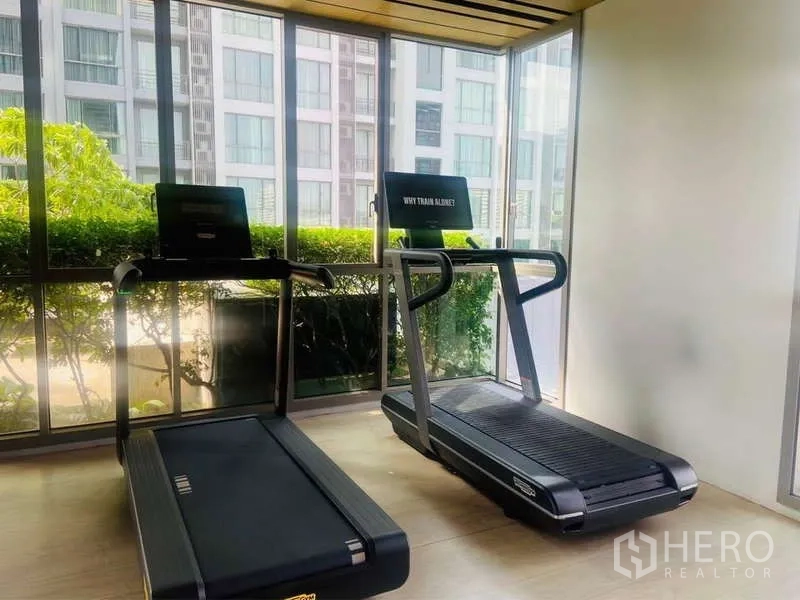 公寓 出售在Watthana, Bangkok - 健身房内的跑步机，面向落地窗与花园景观。