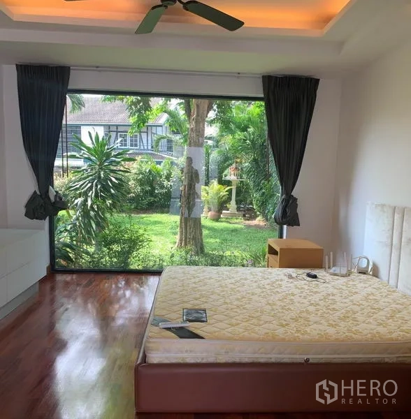 Detached House for rent in Din Daeng, Bangkok - Ground-floor bedroom with floor-to-ceiling window overlooking a green private garden.