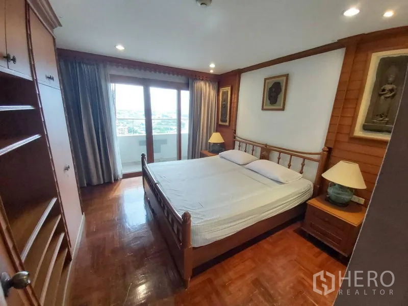 Condominium for rent in Samphanthawong, Bangkok - Bedroom with wooden floor, built‑in storage, and balcony overlooking city and river.