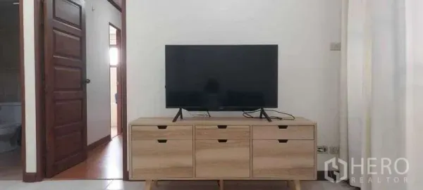 คอนโด ให้เช่าในKhlong Toei, Bangkok - ทีวีจอแบนบนตู้ไม้สีอ่อน ในห้องนั่งเล่นสว่าง เชื่อมประตูไปยังห้องนอนและห้องน้ำ