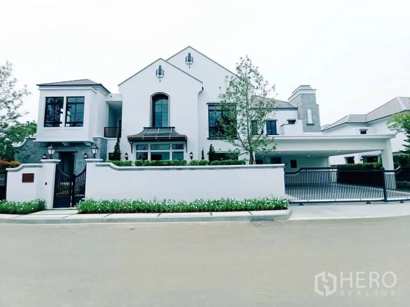 Detached House for sale in Saphan Sung, Bangkok - Contemporary white detached house with gated fence and covered carport.