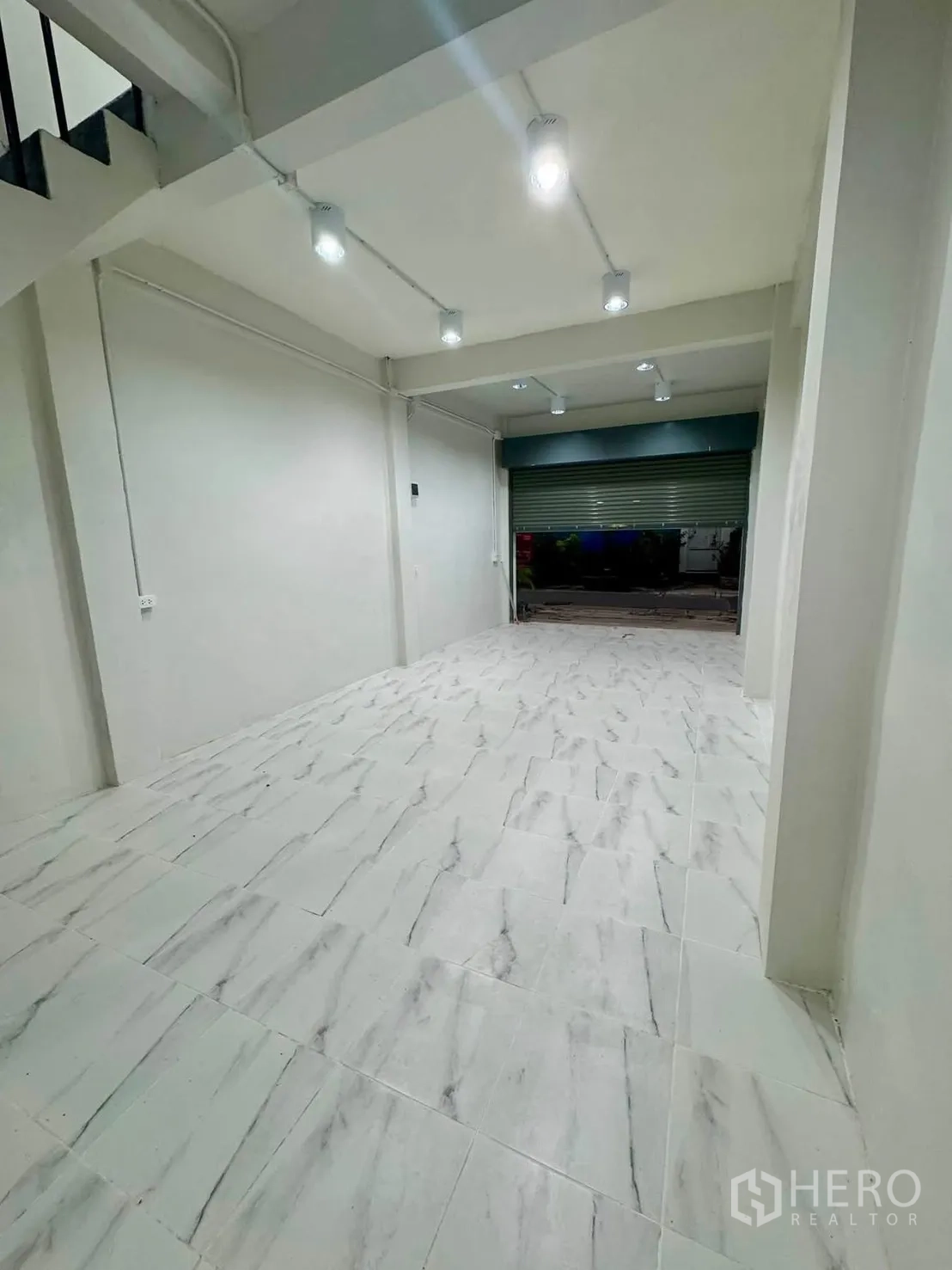 Shophouse for rent in Sathon, Bangkok - Stair landing with window and black metal railings.