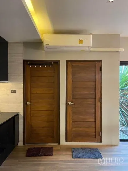 ทาวน์เฮาส์ ขายในBang Phli, Samut Prakan - ประตูไม้ภายในสองบานใต้เครื่องปรับอากาศติดผนังข้างพื้นที่ครัว.