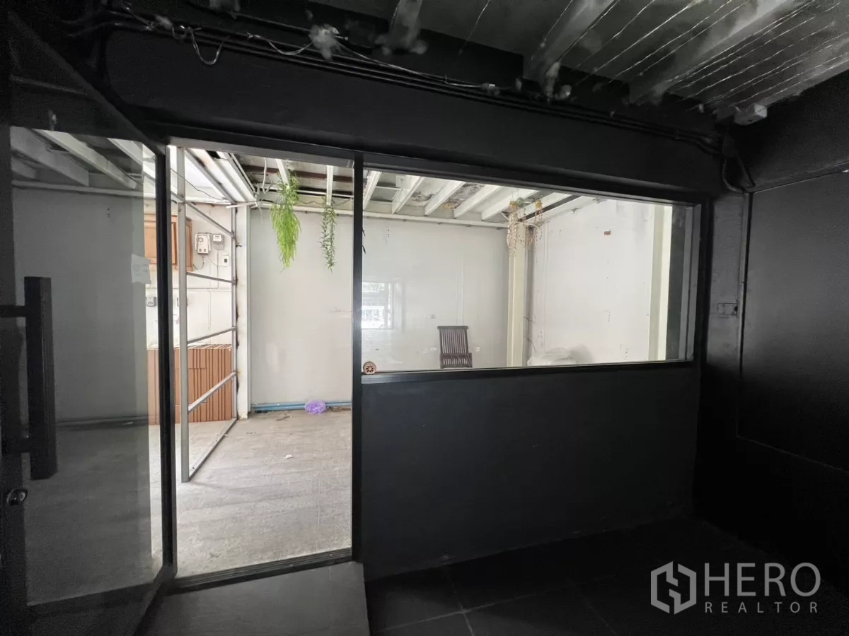 零售空间 出租在Watthana, Bangkok - 后区玻璃隔断，通向多功能房，悬挂绿植。