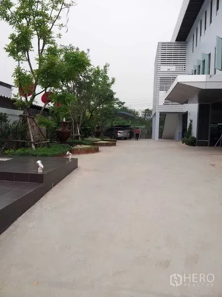 货栈 出租或出售在Bang Phli, Samut Prakan - 仓库侧面宽阔混凝土车道和绿化入口区。