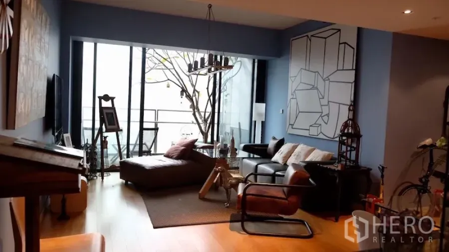 公寓 出租或出售在Sathon, Bangkok - 客厅配落地窗，可通往阳台俯瞰城市景观。