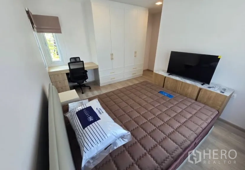 Detached House for rent in Bang Phli, Samut Prakan - Primary bedroom with large wardrobe, TV console, work desk and cushioned bed.