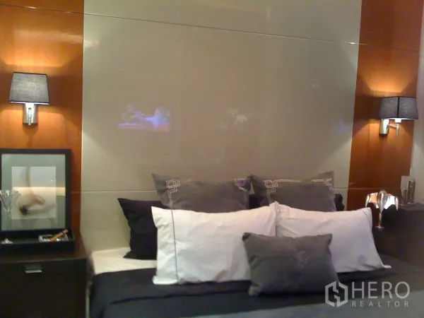 คอนโด ให้เช่าหรือขายในKhlong Toei, Bangkok - ห้องนอนอบอุ่น เตียงบุนวม ชุดเครื่องนอนสีเทาขาว โคมไฟหัวเตียง และงานไม้