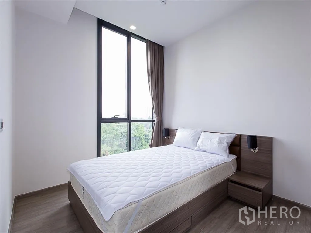 คอนโด for rent in Watthana, Bangkok - ห้องนอนสว่างเตียงคู่ หน้าต่างสูง พื้นไม้ และวิวต้นไม้