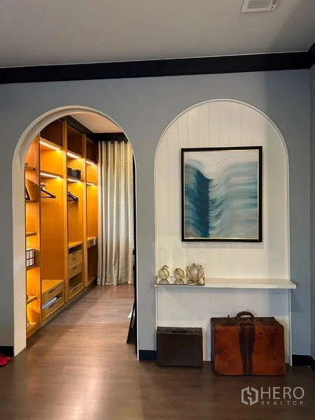 Detached House for rent in Bang Kapi, Bangkok - Hallway with twin arched niches, wall art and an illuminated built-in wardrobe.