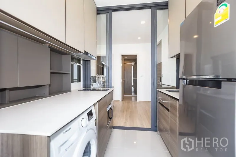 คอนโด ให้เช่าในPhaya Thai, Bangkok - ครัวแบบแกลลีย์ ตู้เก็บของครบ เคาน์เตอร์ยาว ตู้เย็น และเครื่องซักผ้าหลังประตูกระจกบานเลื่อน