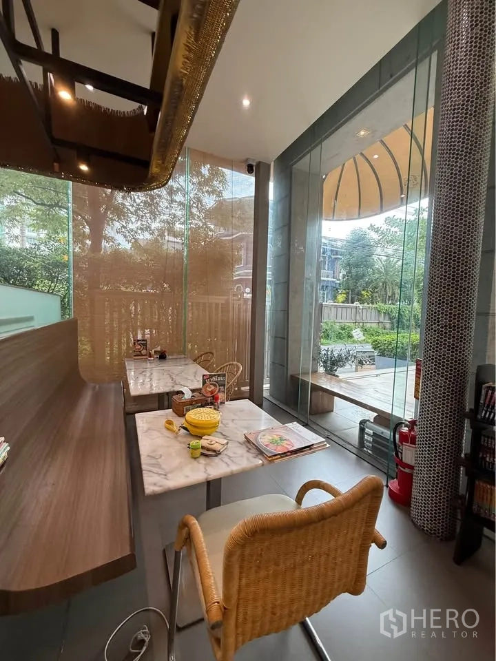 Retail Space for rent in Watthana, Bangkok - Cozy indoor seating corner with marble tables next to floor-to-ceiling glass.