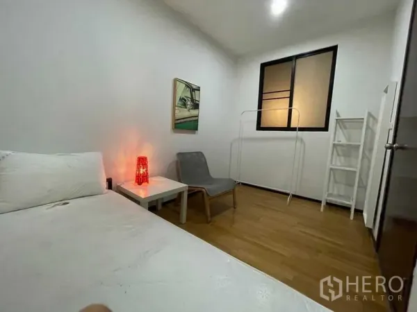 Condominium for rent in Din Daeng, Bangkok - Cozy second bedroom with bed, lounge chair and side table by the window.