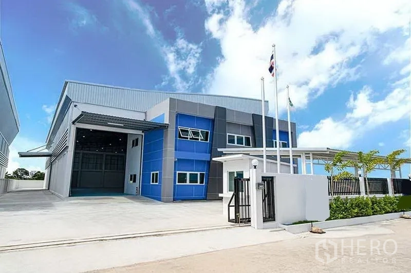 Warehouse for rent in Bang Bo, Samut Prakan - Front facade of the warehouse complex with wide driveway and landscaped perimeter fence.