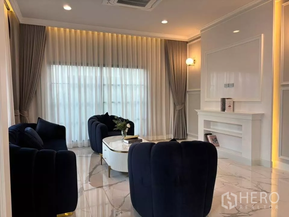 独立式住宅 出租在Bang Phli, Samut Prakan - 温馨起居角，落地窗帘与经典墙板细节。