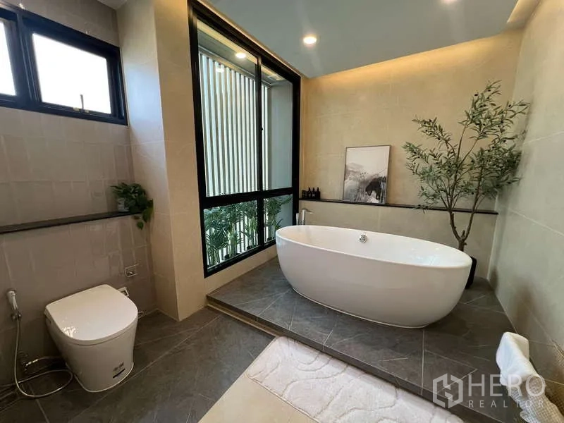Detached House for sale in Suan Luang, Bangkok - Luxury bathroom with freestanding oval bathtub on a raised platform by a large window